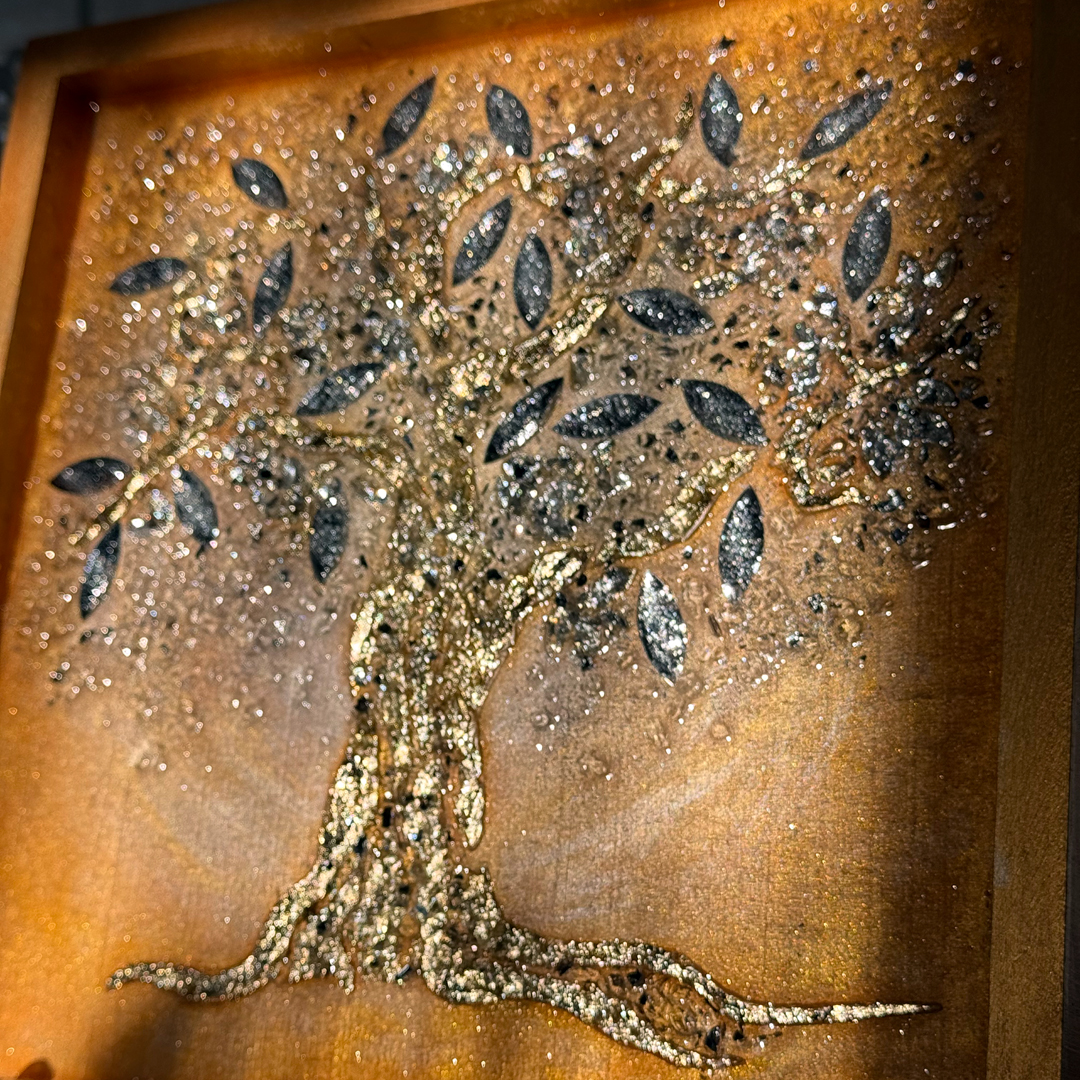 Ein Lebensbaum ist auf goldenem Grund mit Strukturpaste dargestellt. Die Äste und der Stamm sind mit schimmerndem Blattgold überzogen, was dem Gemälde eine glamouröse und prachtvolle Ausstrahlung verleiht. Die Blätter bestehen aus Spiegelglas und sind zusätzlich mit Epoxidharz beschichtet, was ihnen mehr Volumen verleiht und einen Linseneffekt erzeugt. Durch das Zusammenspiel von Licht und Epoxidharzschicht weckt das Gemälde ein Gefühl von Freude und Begeisterung und lädt zum Berühren ein.